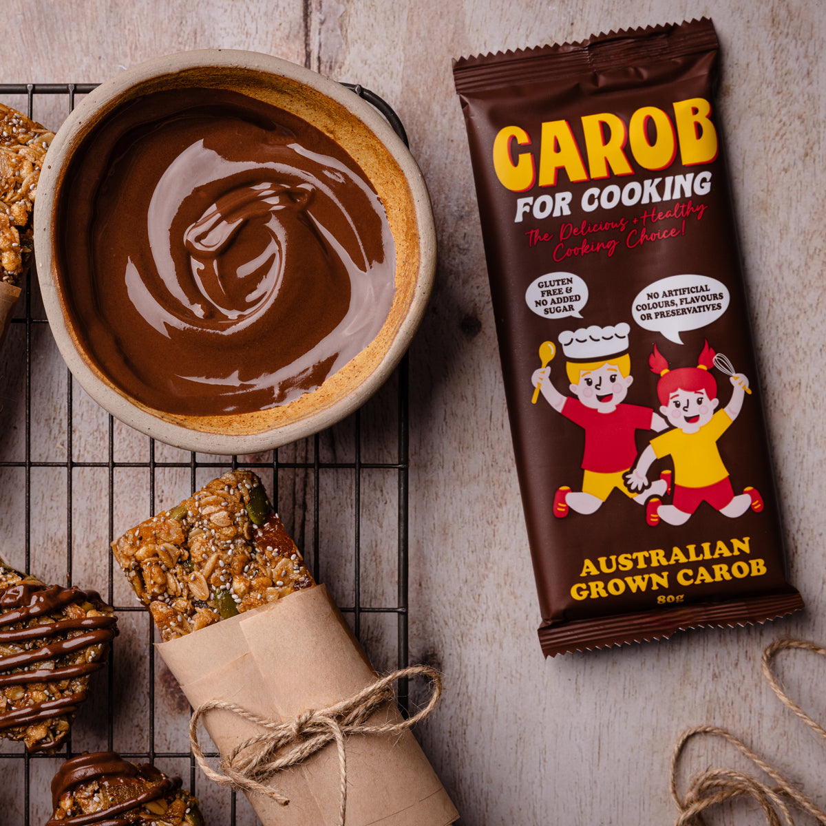 Bowl of smooth, melting carob chocolate being drizzled over nut-free muesli bars | Carob for Cooking healthy baking recipe